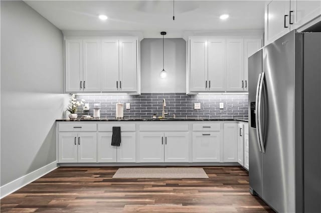 kitchen with sink, white cabinets, tasteful backsplash, hanging light fixtures, and stainless steel refrigerator with ice dispenser