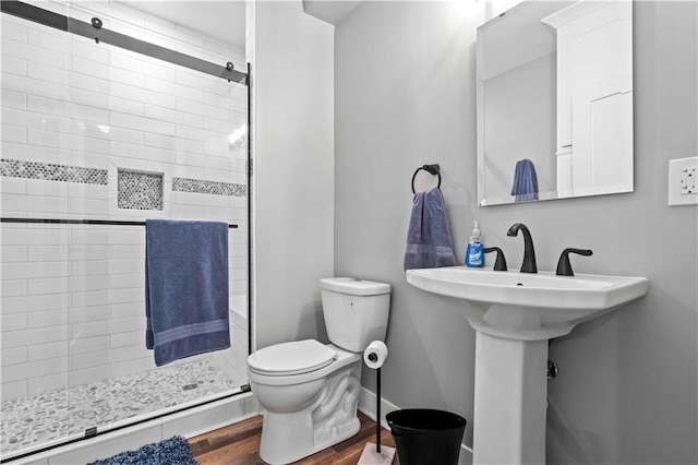 bathroom with toilet, hardwood / wood-style flooring, and a shower with door