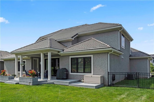 back of property featuring cooling unit, a patio area, a yard, and a wooden deck