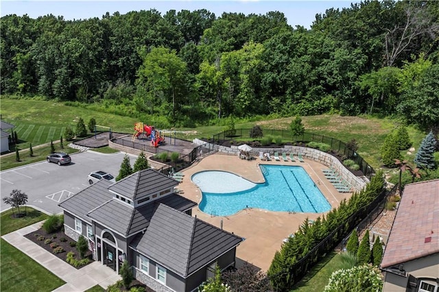 view of swimming pool with a lawn, a playground, and a patio