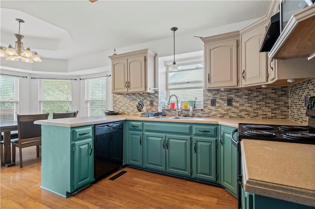 kitchen with kitchen peninsula, hanging light fixtures, light hardwood / wood-style flooring, black appliances, and sink