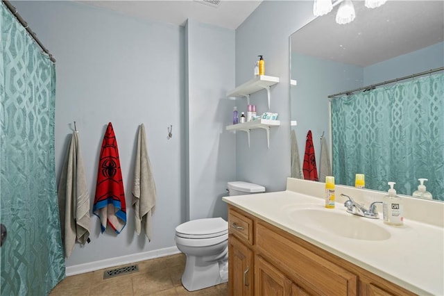 bathroom with toilet, vanity, and tile patterned floors