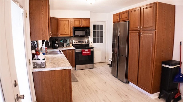 kitchen featuring decorative backsplash, sink, light hardwood / wood-style flooring, and appliances with stainless steel finishes