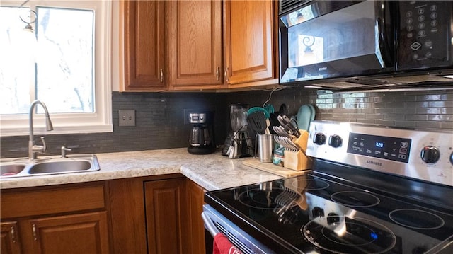 kitchen with stainless steel electric range oven, sink, and tasteful backsplash