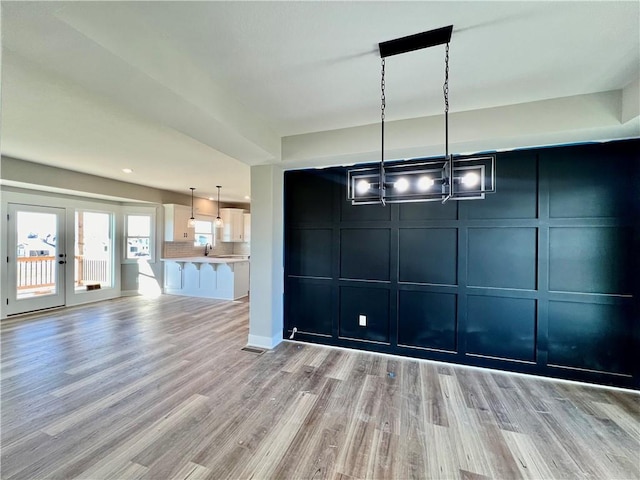 unfurnished dining area with light hardwood / wood-style floors and sink