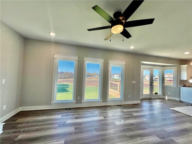 unfurnished living room with ceiling fan, french doors, and dark wood-type flooring