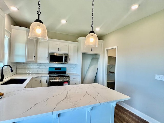 kitchen featuring white cabinets, decorative light fixtures, sink, and stainless steel appliances