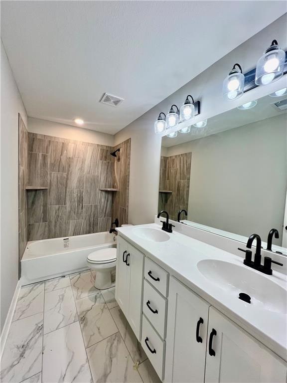 full bathroom featuring vanity, toilet, and tiled shower / bath