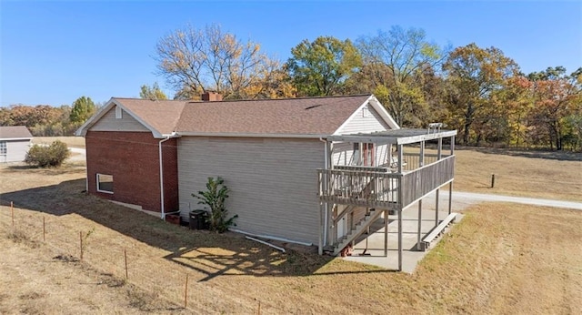 view of property exterior with a lawn and a wooden deck