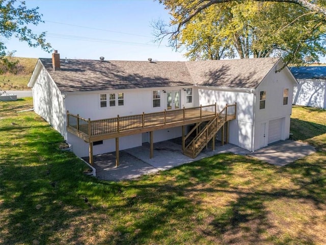 back of property with a lawn, a garage, and a wooden deck