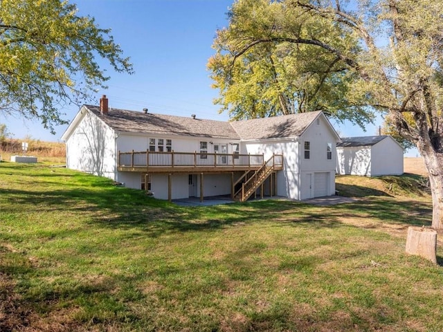 rear view of property with a garage, a lawn, and a wooden deck