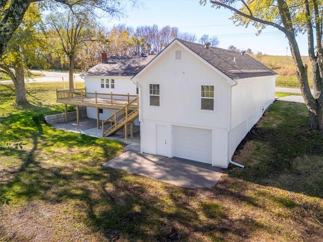 rear view of property with a garage, a yard, a patio, and a wooden deck