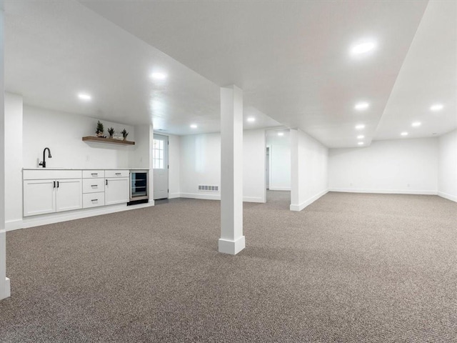 basement featuring carpet, wet bar, and beverage cooler