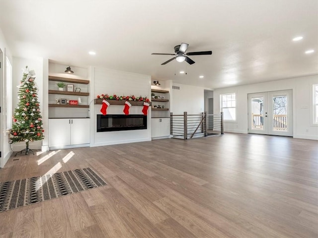 unfurnished living room with ceiling fan, french doors, and wood-type flooring