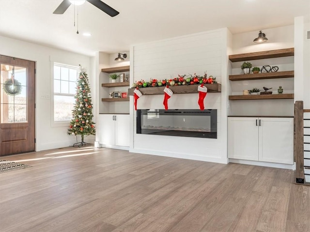 unfurnished living room featuring light hardwood / wood-style floors and ceiling fan