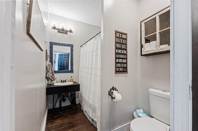 bathroom with hardwood / wood-style floors, toilet, and sink