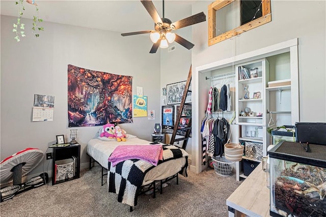 bedroom featuring carpet, ceiling fan, a high ceiling, and a closet