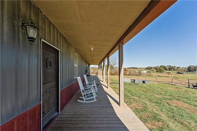 wooden deck featuring a lawn and a rural view