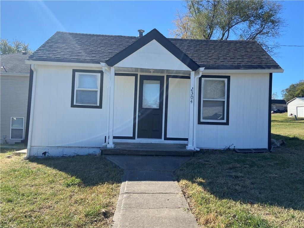 bungalow-style home with a front lawn