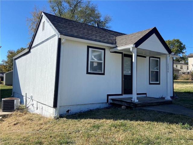 view of front of house with central AC and a front lawn