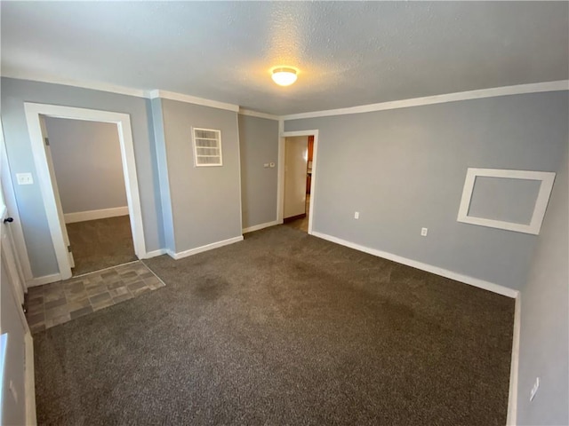 unfurnished room with crown molding, dark colored carpet, and a textured ceiling