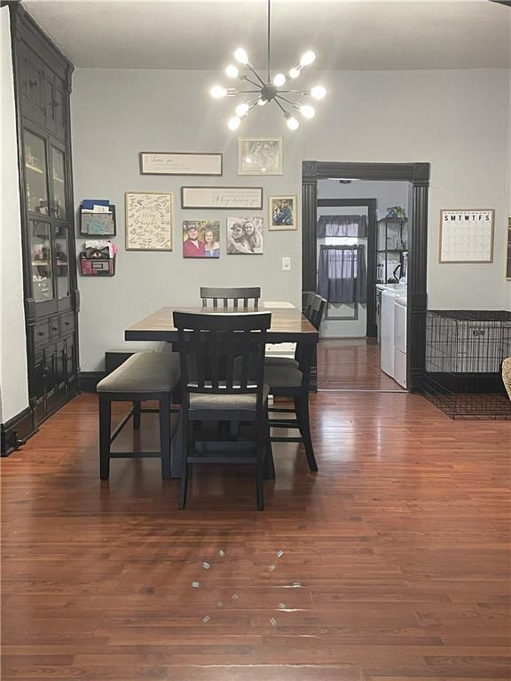 dining room featuring a chandelier, dark wood-type flooring, and independent washer and dryer