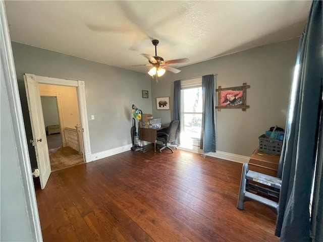 office with ceiling fan and dark wood-type flooring