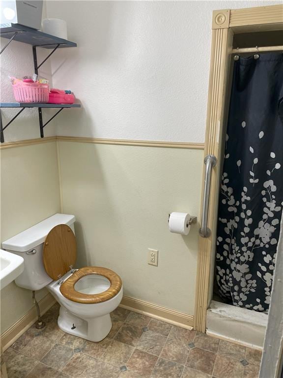 bathroom featuring walk in shower and toilet