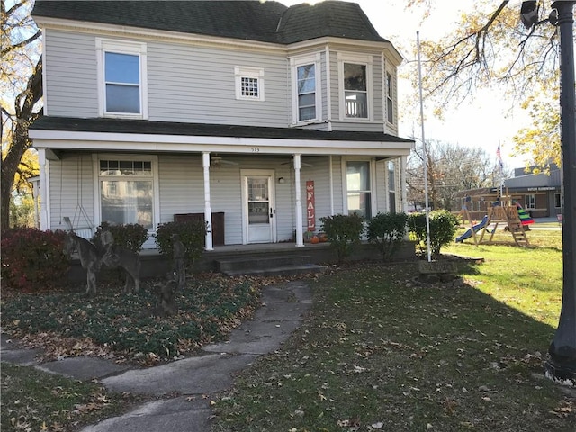 513 W Ohio St, Butler, MO 64730 - view of front facade featuring a porch, a front lawn, a playground, and roof with shingles
