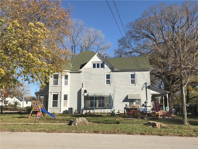 back of house with a playground, a lawn, cooling unit, and a trampoline