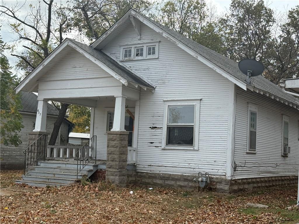 607 W 3rd St, Coffeyville, KS 67337 - view of front of property featuring a porch and roof with shingles