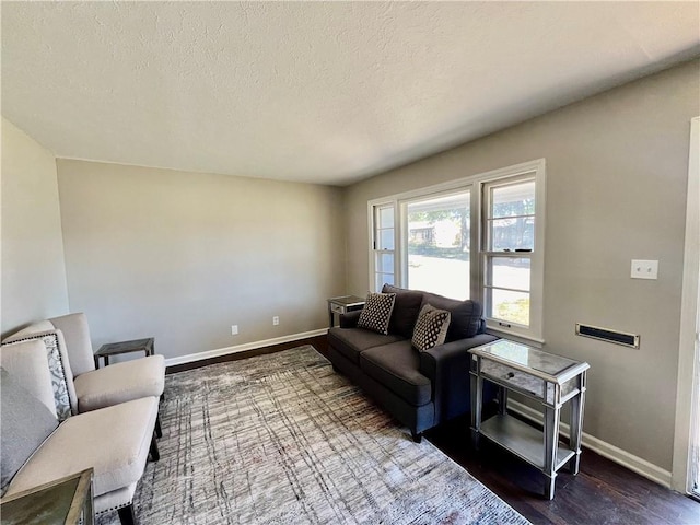 living room with dark wood-type flooring and a textured ceiling