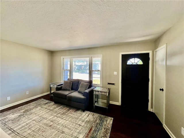 living room with dark wood-type flooring and a textured ceiling