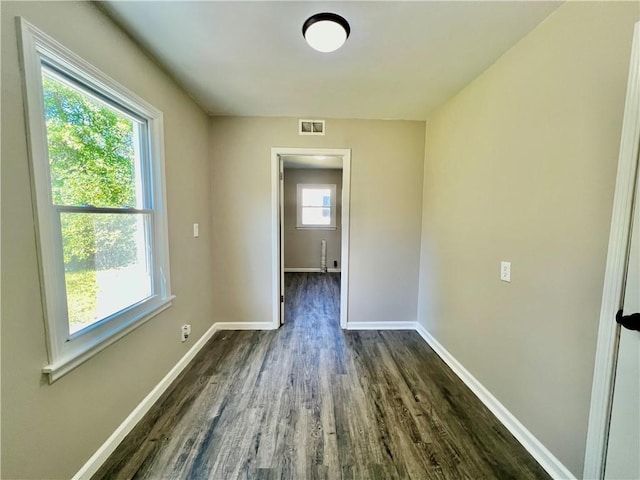 unfurnished room with dark hardwood / wood-style flooring