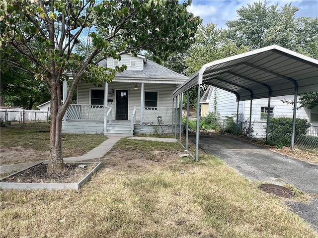 bungalow with covered porch, a front yard, and a carport