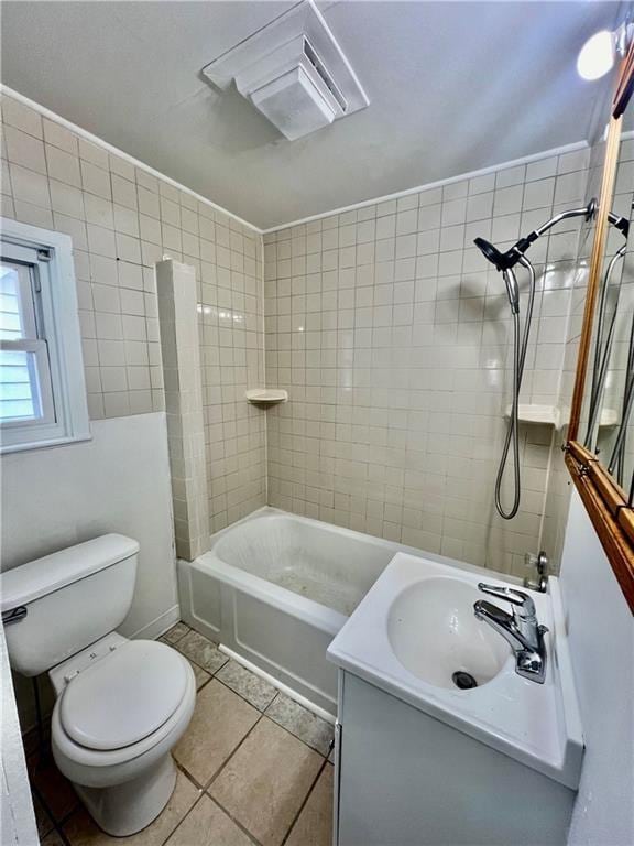 full bathroom with tiled shower / bath, vanity, toilet, and tile patterned flooring