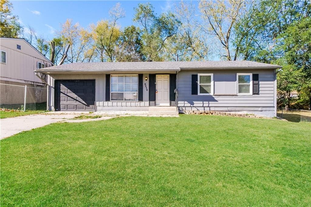 ranch-style house featuring a front lawn and a garage