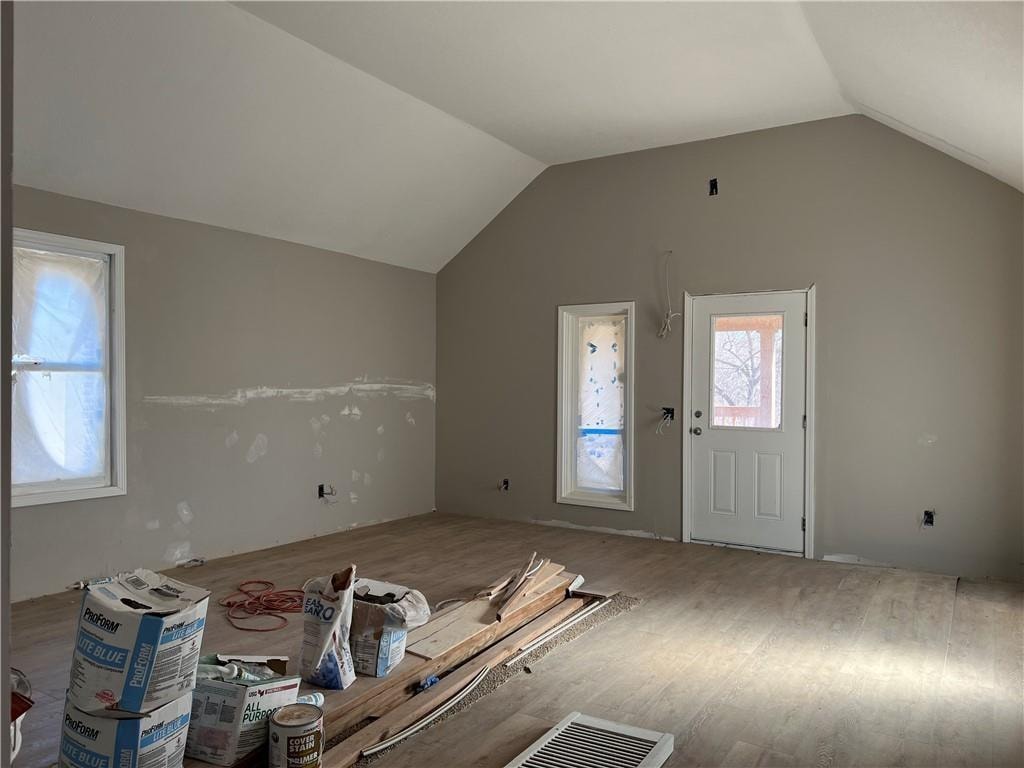 entrance foyer with wood-type flooring and vaulted ceiling