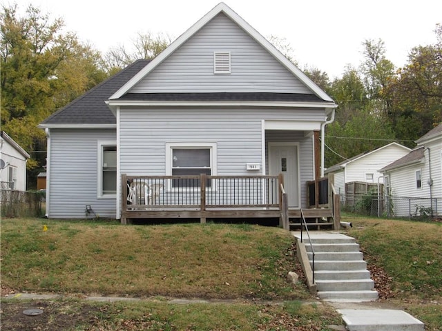 back of house with a deck and a yard