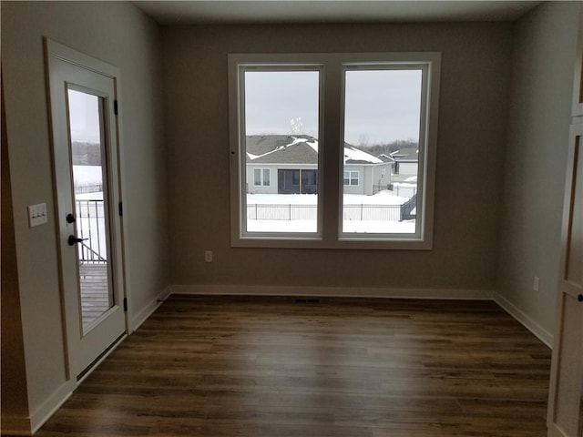 empty room featuring dark wood-style floors and baseboards