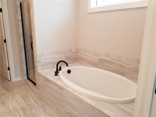 full bathroom featuring a stall shower and a bath