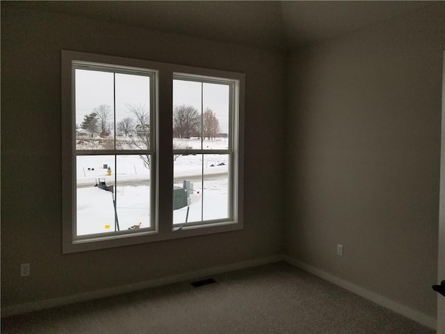 unfurnished room with carpet, visible vents, and baseboards