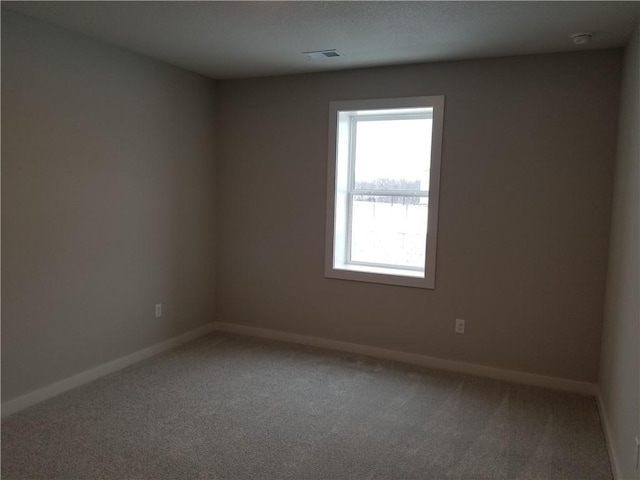 unfurnished room featuring baseboards, visible vents, and light colored carpet