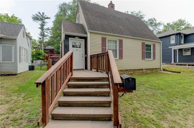 view of front of house featuring central air condition unit, a front lawn, and a wooden deck