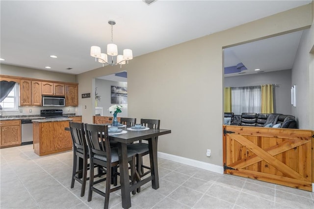 dining space with light tile patterned floors and an inviting chandelier