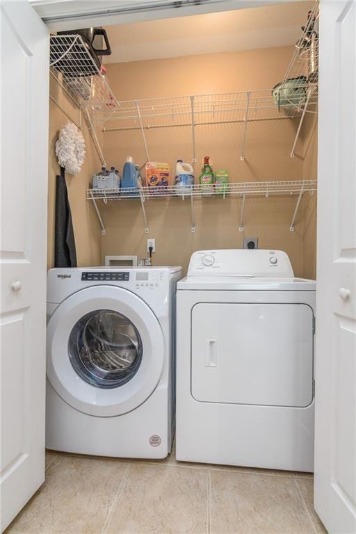 laundry area with independent washer and dryer and tile patterned floors