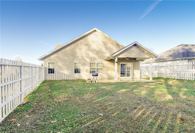 rear view of house with a lawn and ceiling fan