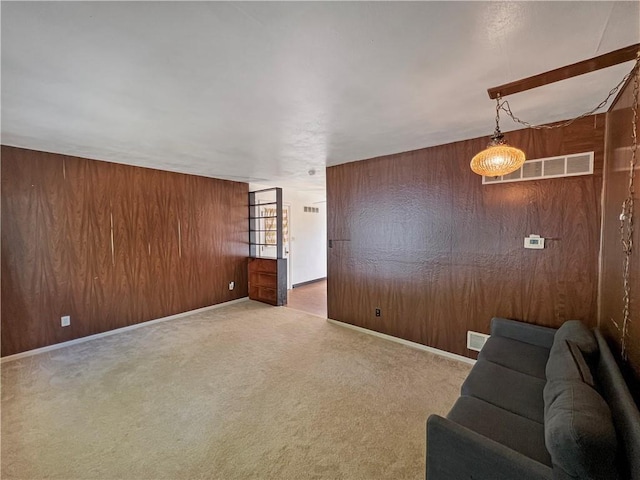 unfurnished living room with wooden walls and carpet flooring