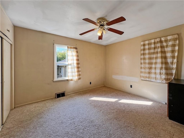 carpeted spare room with ceiling fan