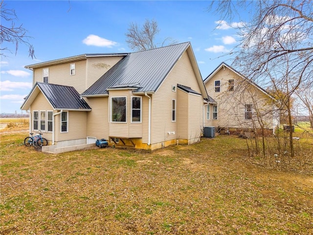 rear view of house featuring a yard and central AC unit